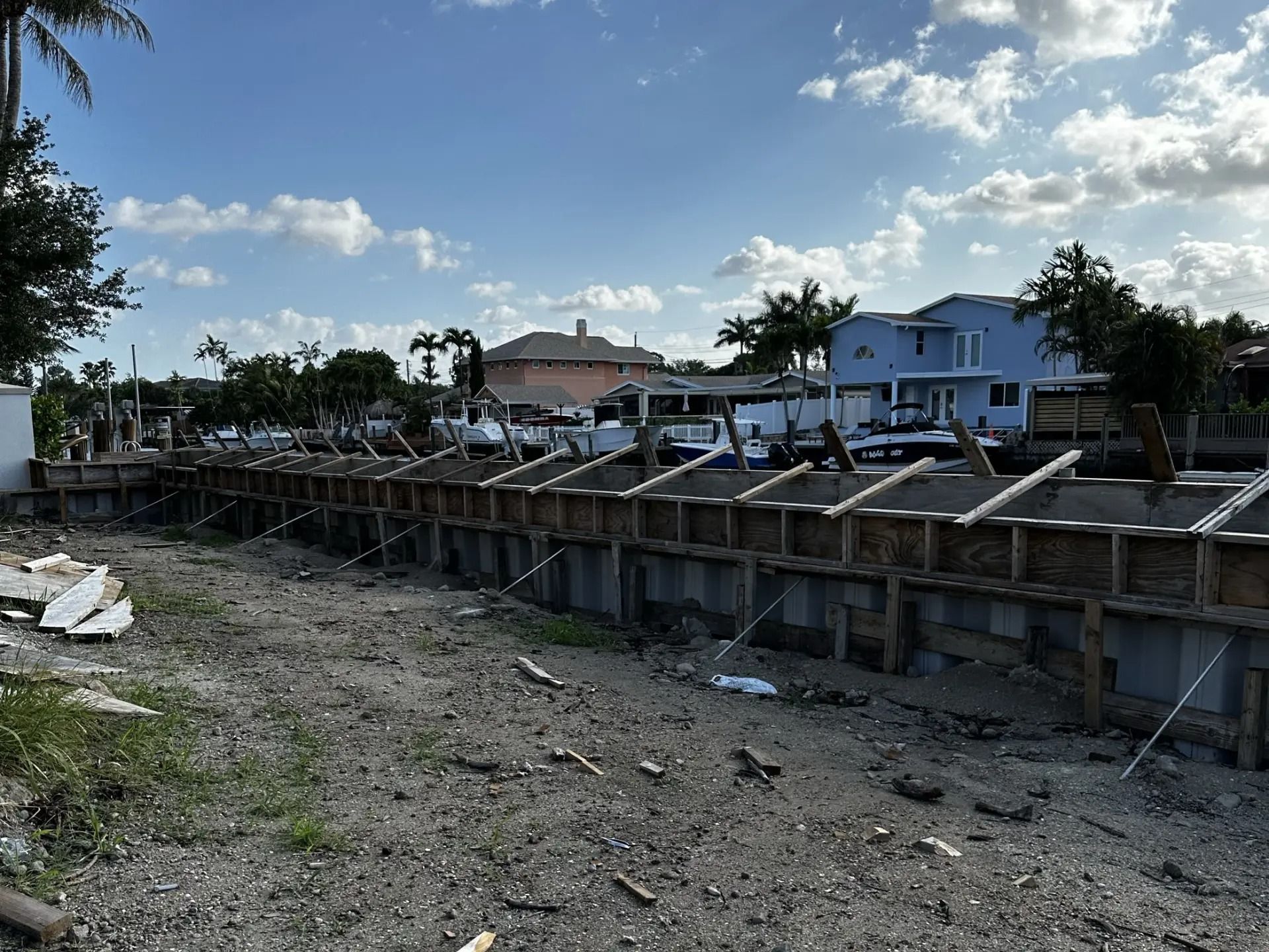 A construction site with a lot of concrete walls and a house in the background.