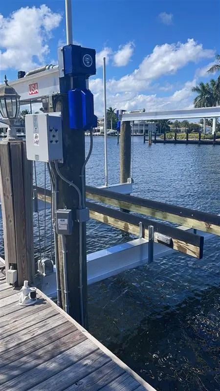 A dock with a boat lift attached to it next to a body of water.