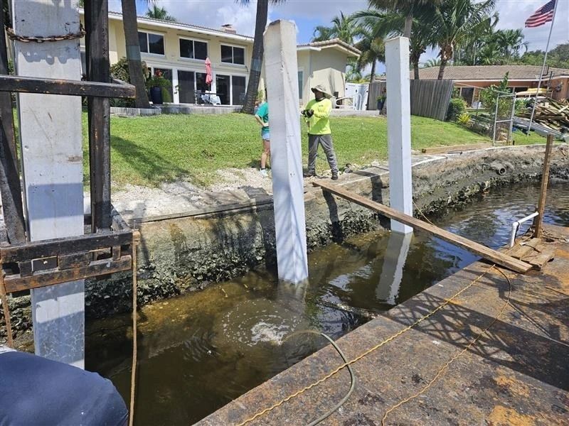 A man is standing on a bridge over a body of water.