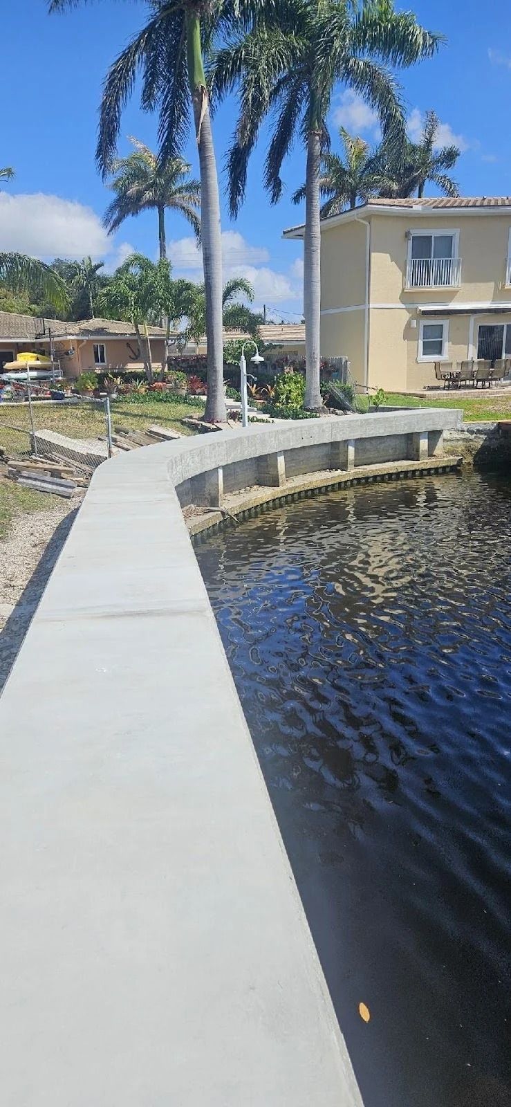 A dock leading to a house next to a body of water.