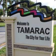 A welcome to tamarac the city for your life sign is sitting in the grass.