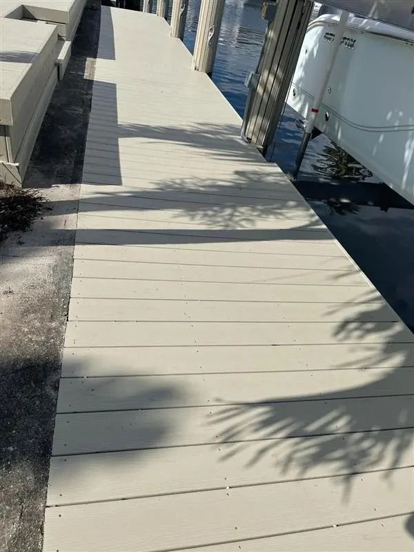 A boat is docked on a dock next to a palm tree.