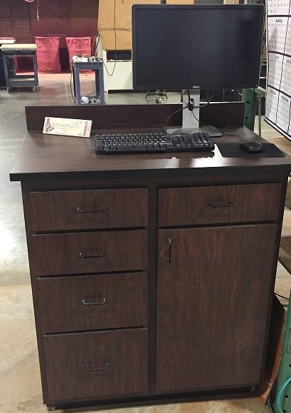 A wooden desk with a computer and keyboard on it.