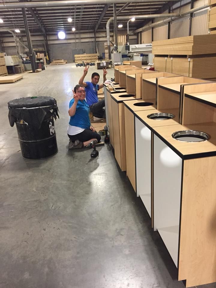 A man and a woman are posing for a picture in a warehouse