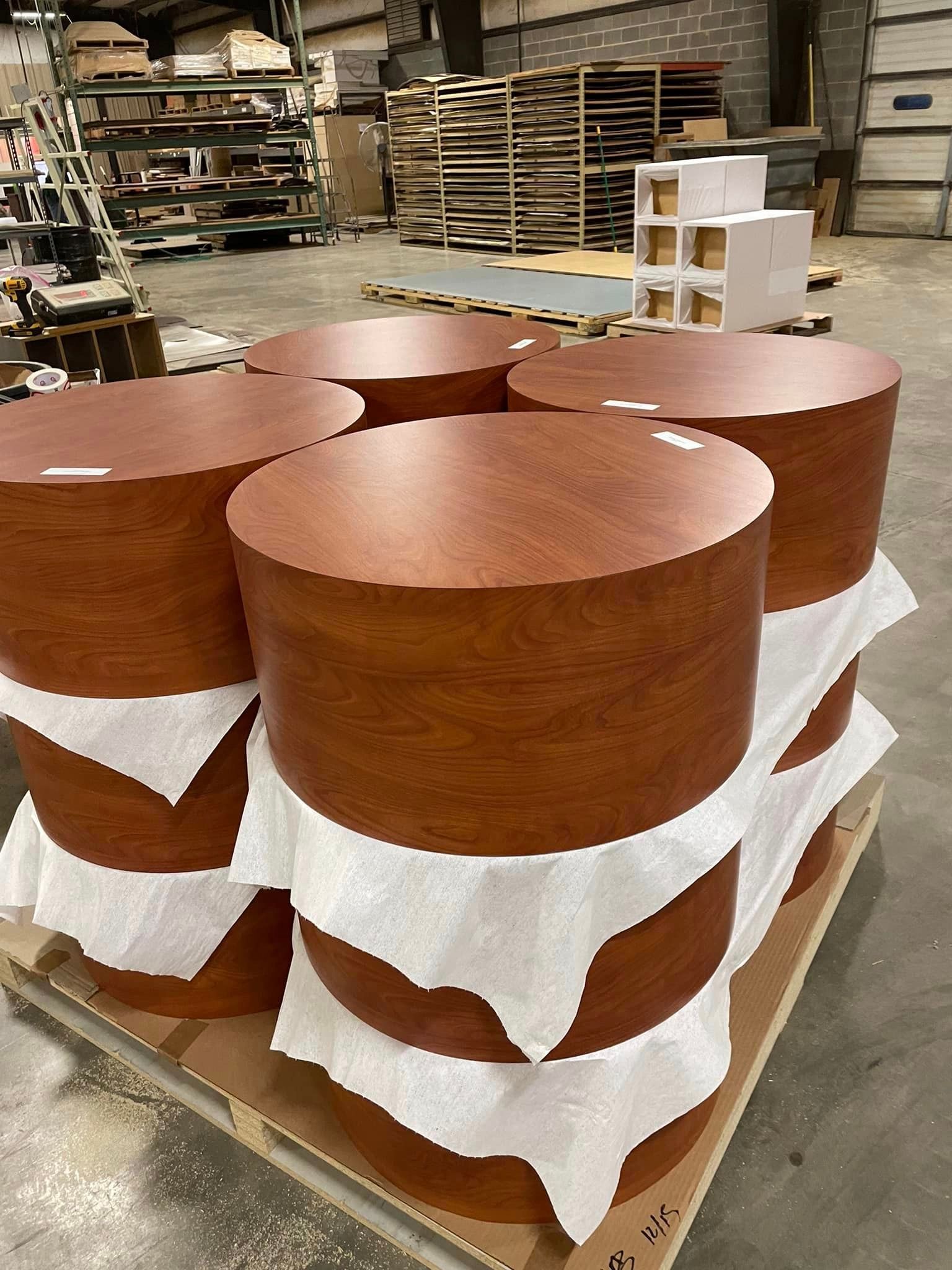 A pallet of wooden cylinders sitting on top of each other in a warehouse.