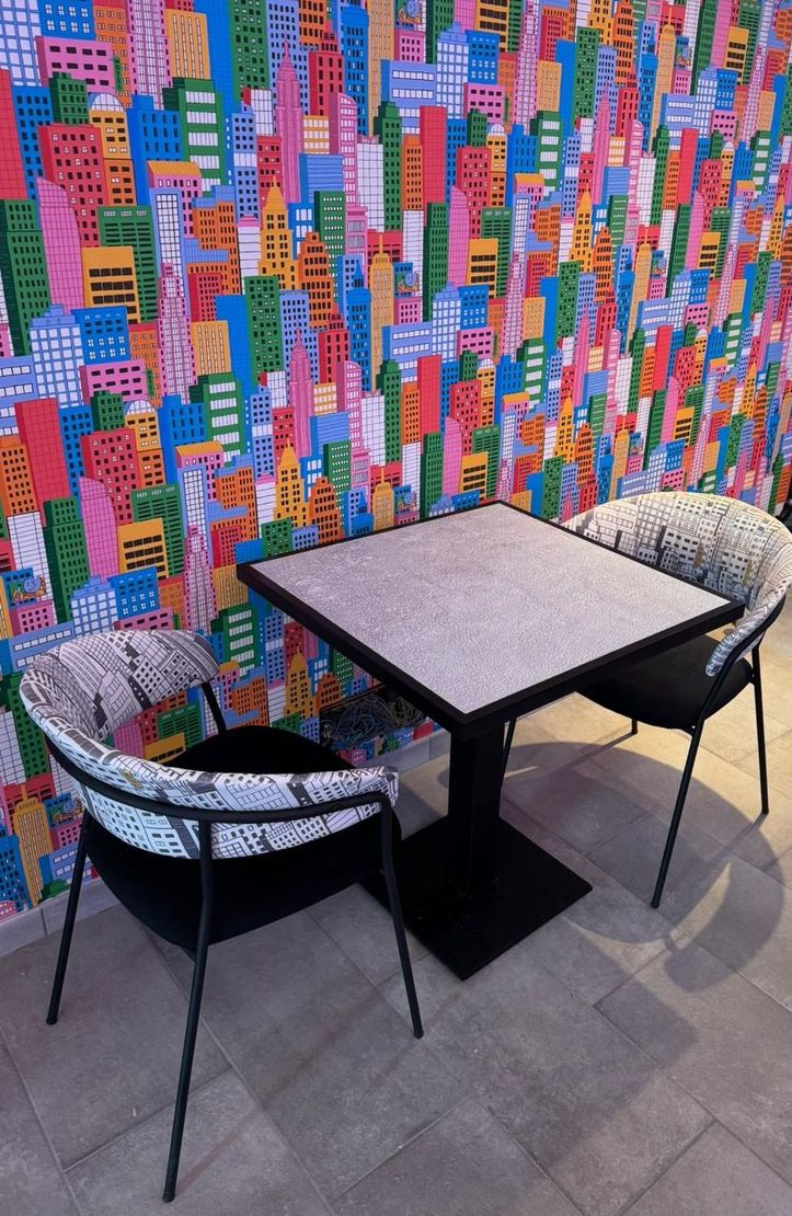 Un ristorante con tavoli e sedie e una vetrina con prodotti alimentari.