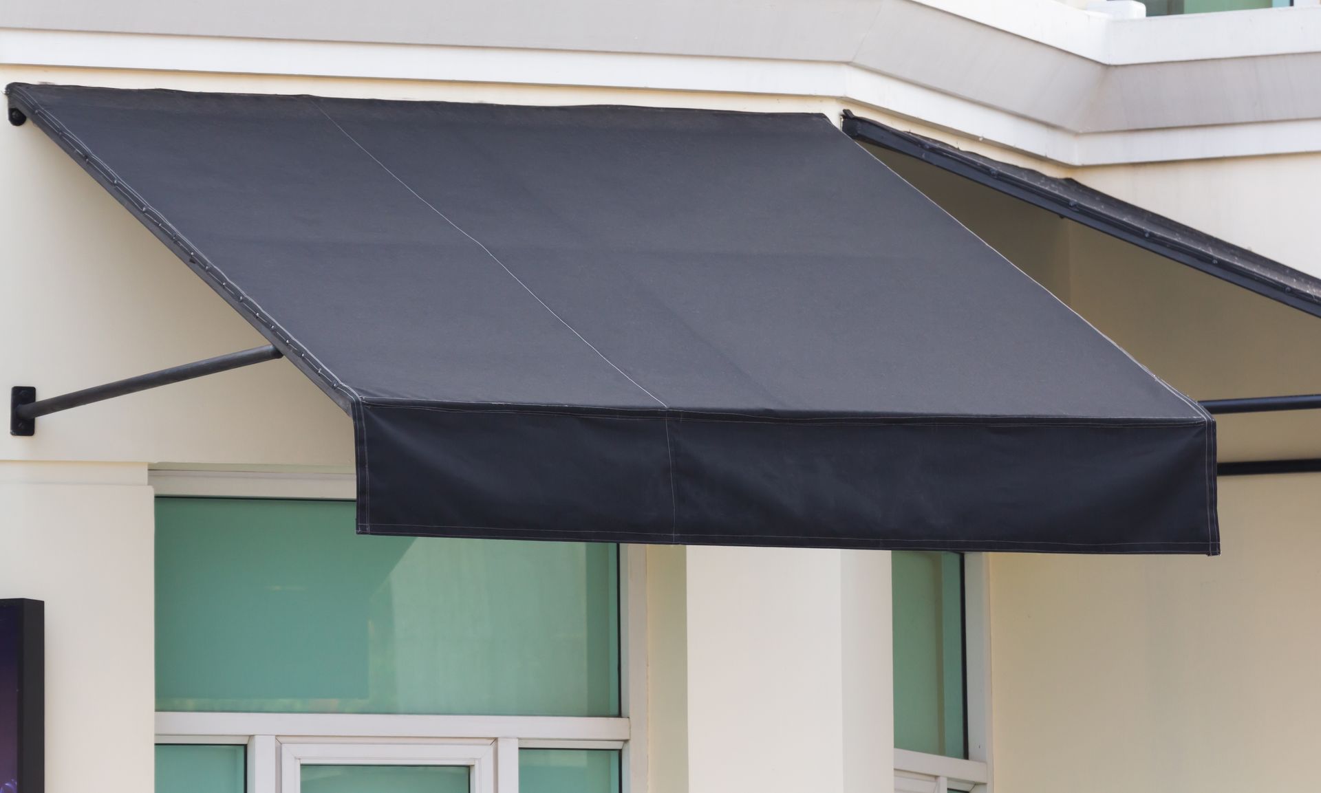 A black awning is on the side of a building