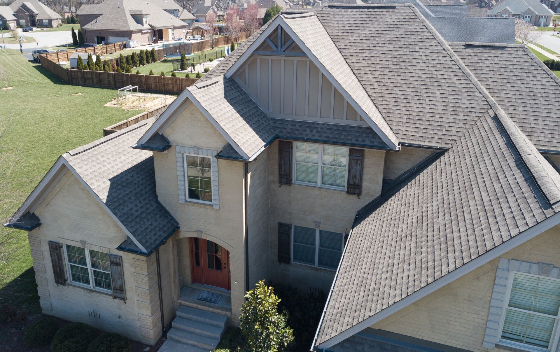 An aerial view of a large house with a gray roof.