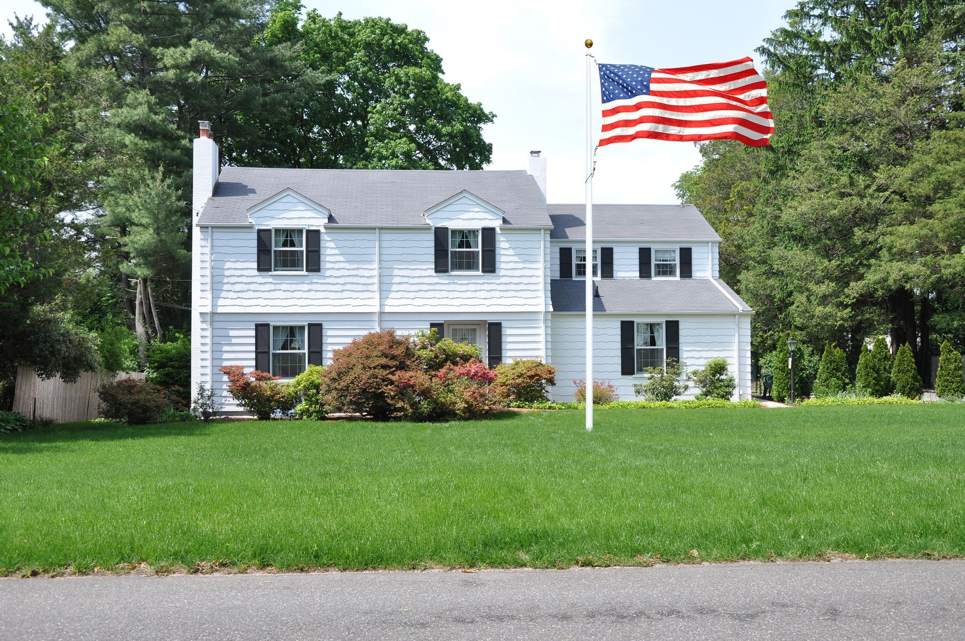 An american flag is flying in front of a white house