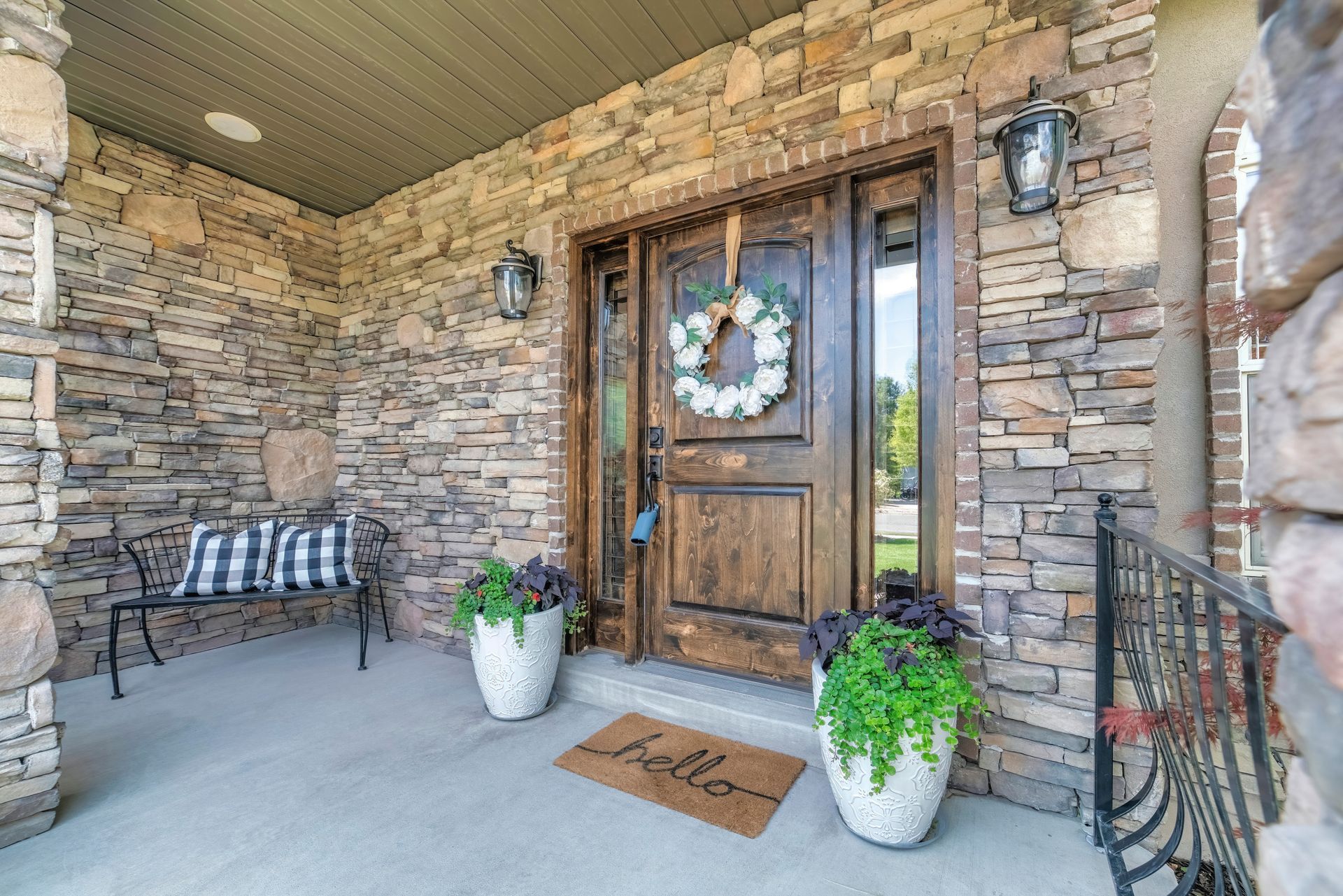 The front door of a house with a wreath on it and a welcome mat.