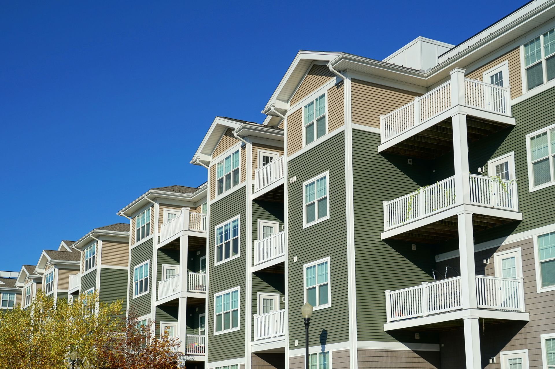 A large apartment building with green siding and white balconies