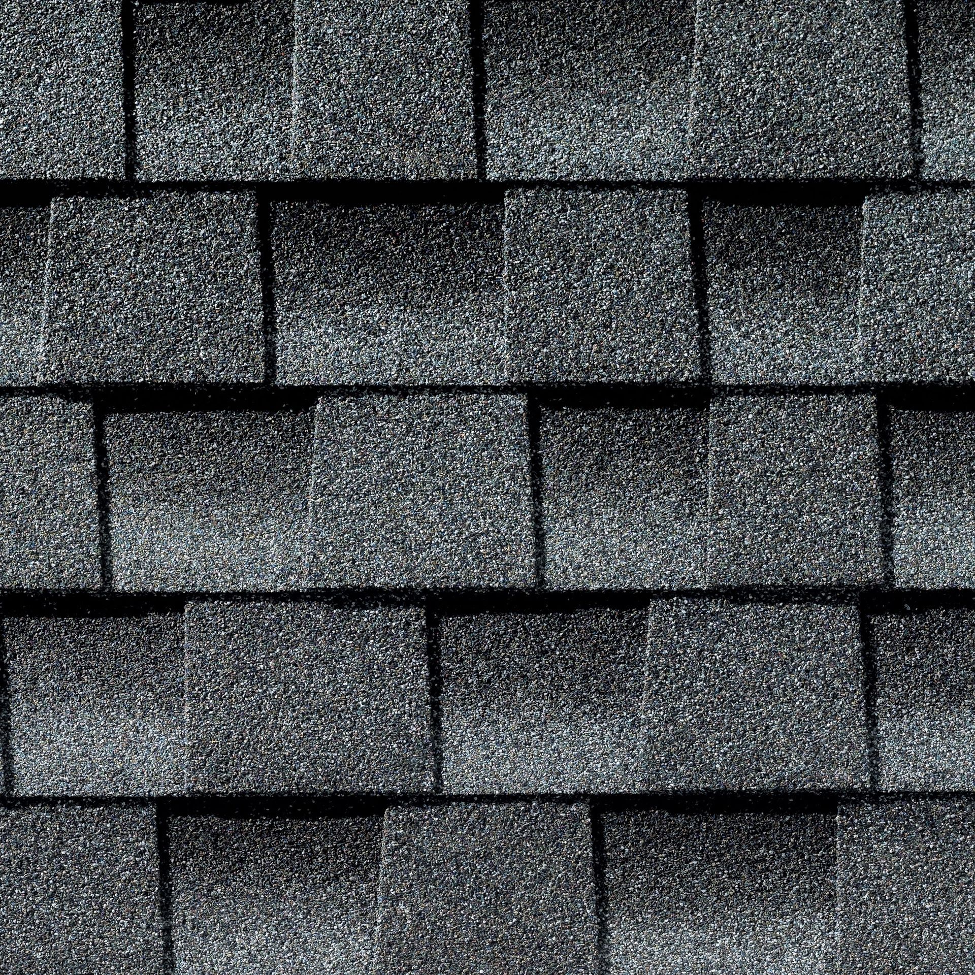 A close up of a row of black shingles on a roof.