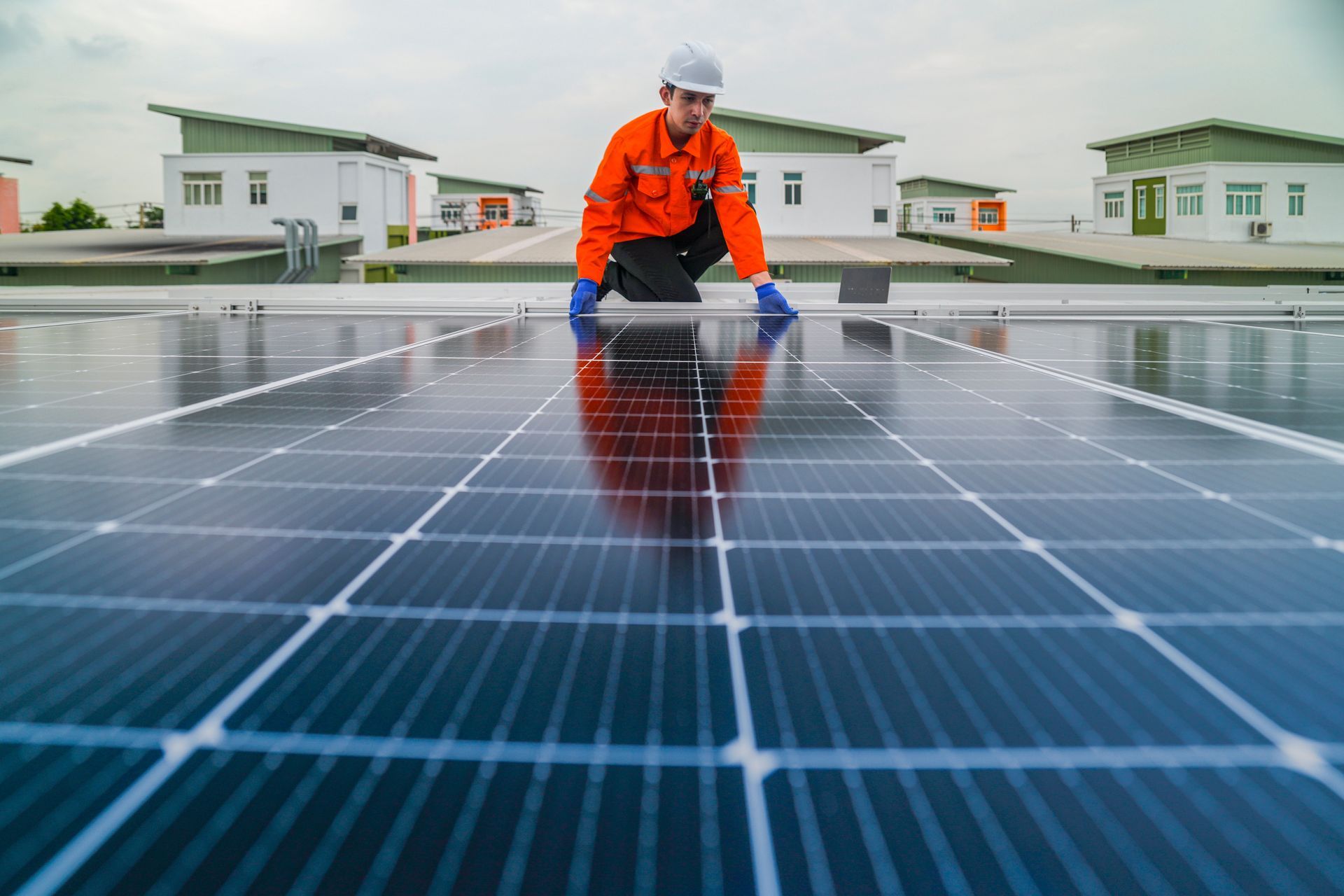 A man is working on a solar panel on the roof of a building.