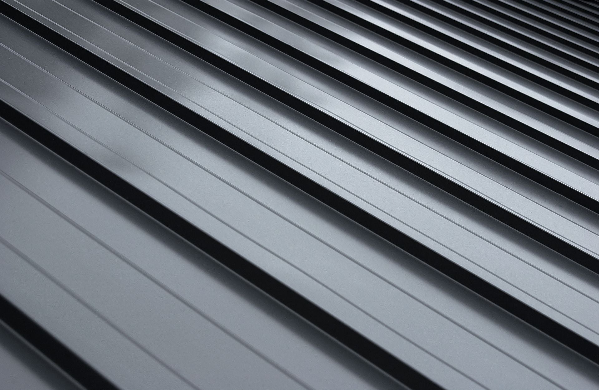 A close up of a black metal roof with a diagonal pattern.