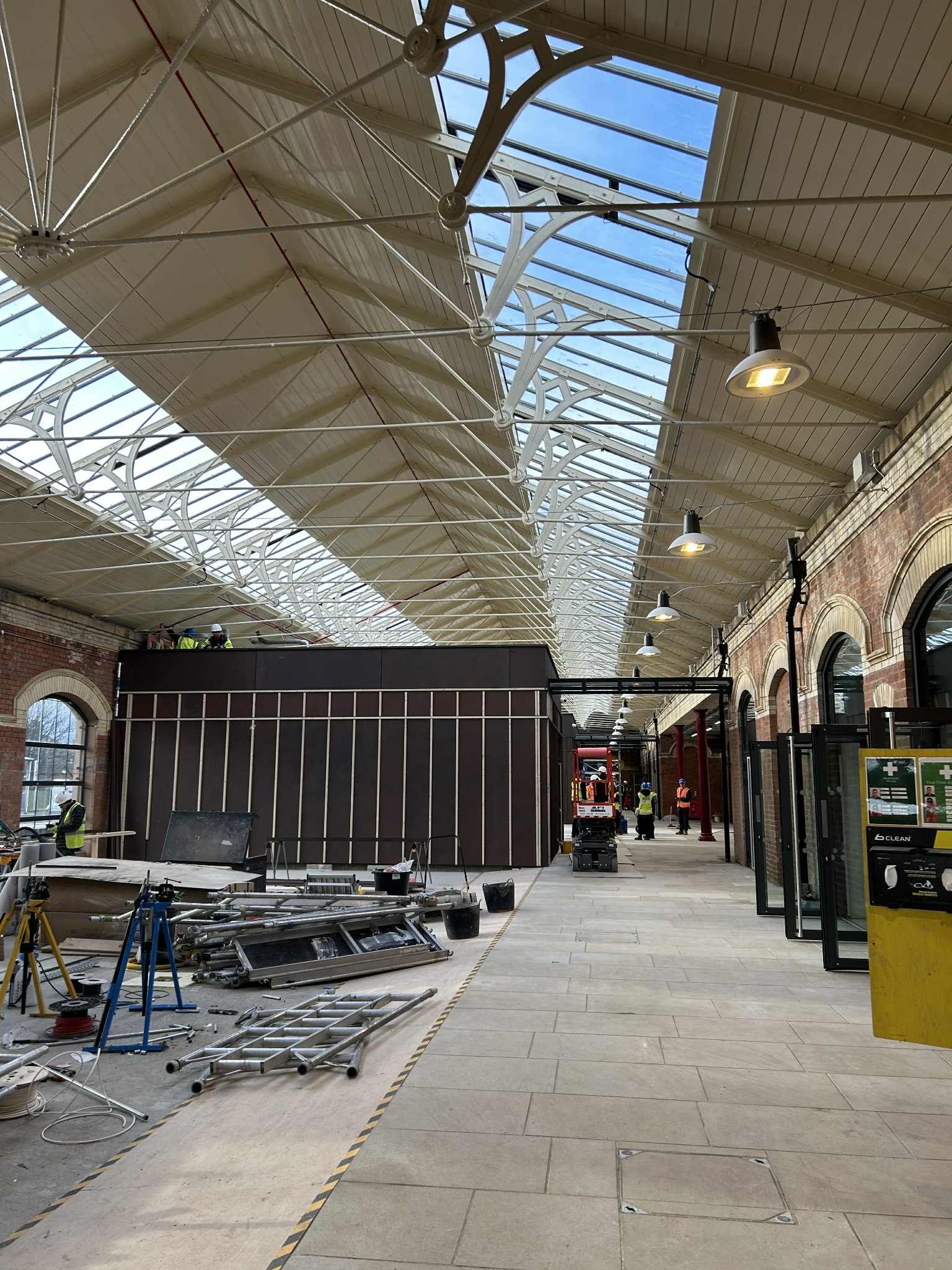 Construction work underway inside a covered railway station with workers and tools in Redcar.