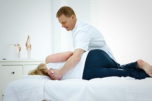 Male physiotherapist massaging a senior woman's back