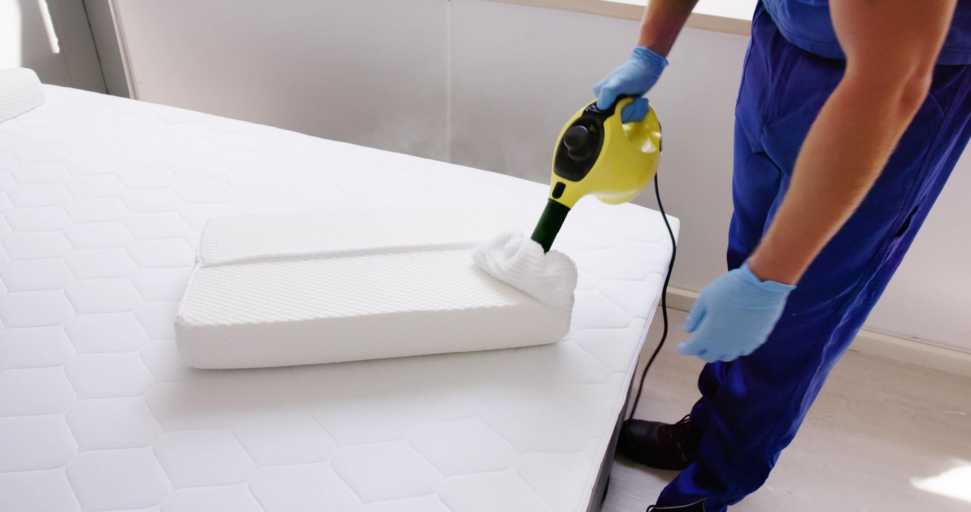 A Person is Cleaning a Mattress With a Spray Bottle — Rozken Pest Control Services In Port Macquarie, NSW