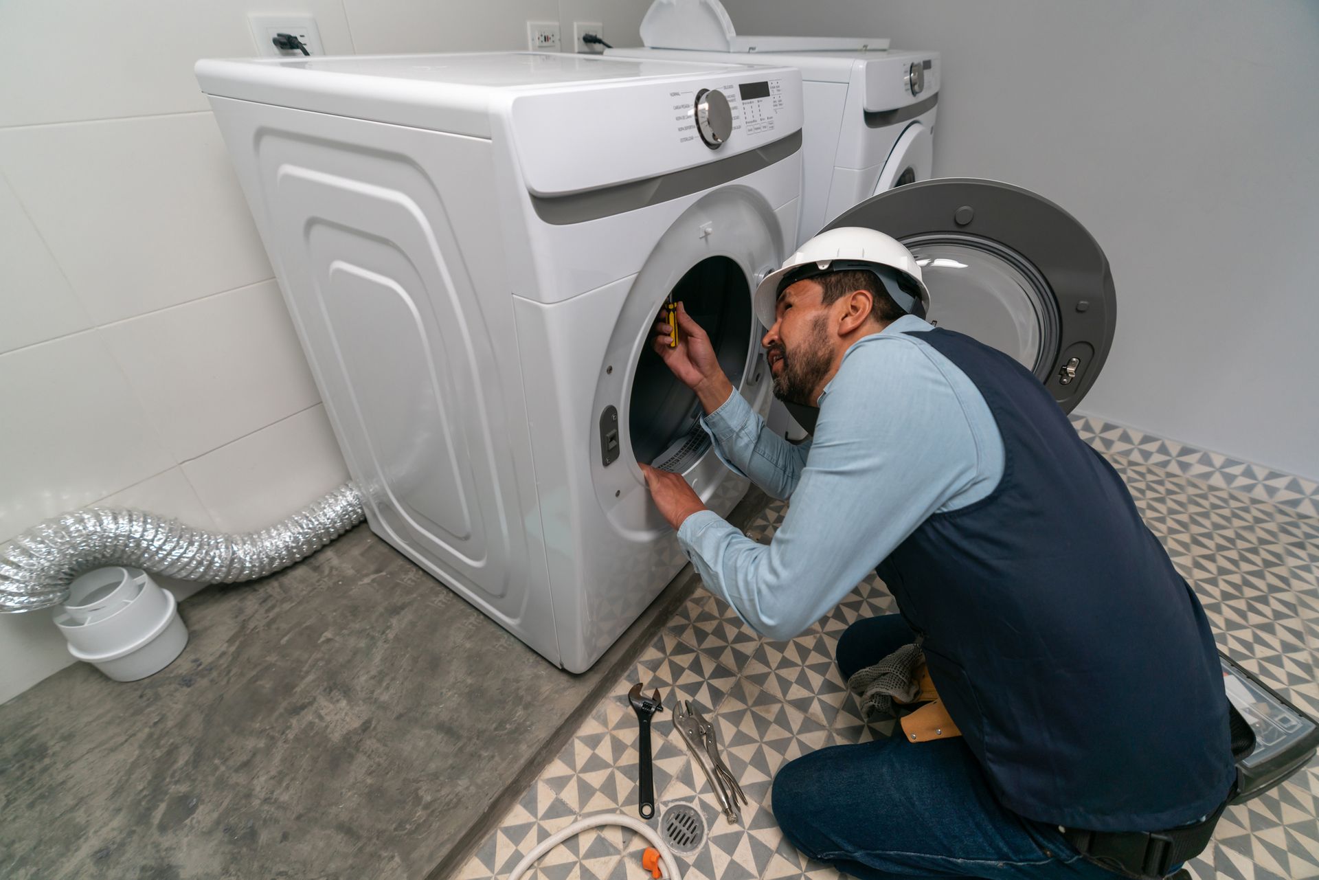 A man repairing a machine, highlighting dryer repair and general appliance maintenance.