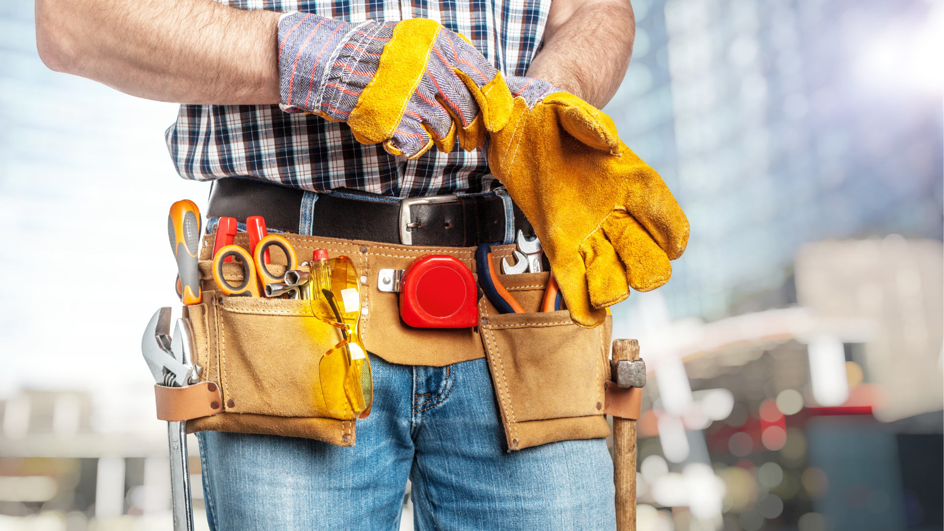 A man is wearing a tool belt and gloves.