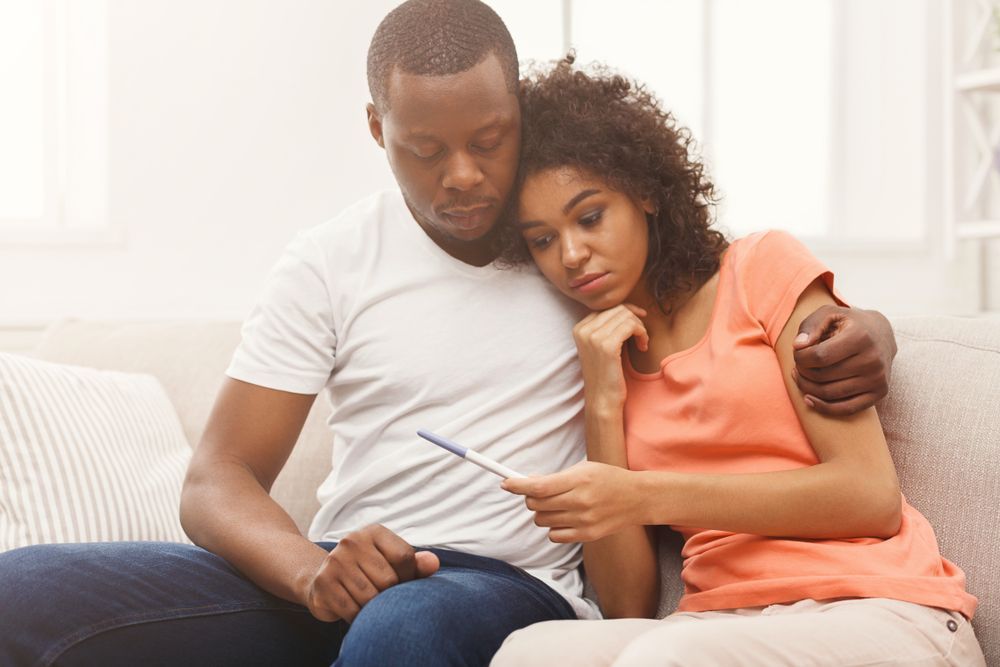 A young African-American couple reading a pregnancy test together.