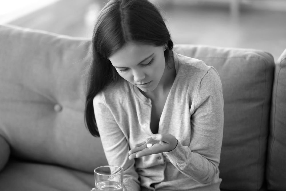 woman contemplating taking an abortion pill