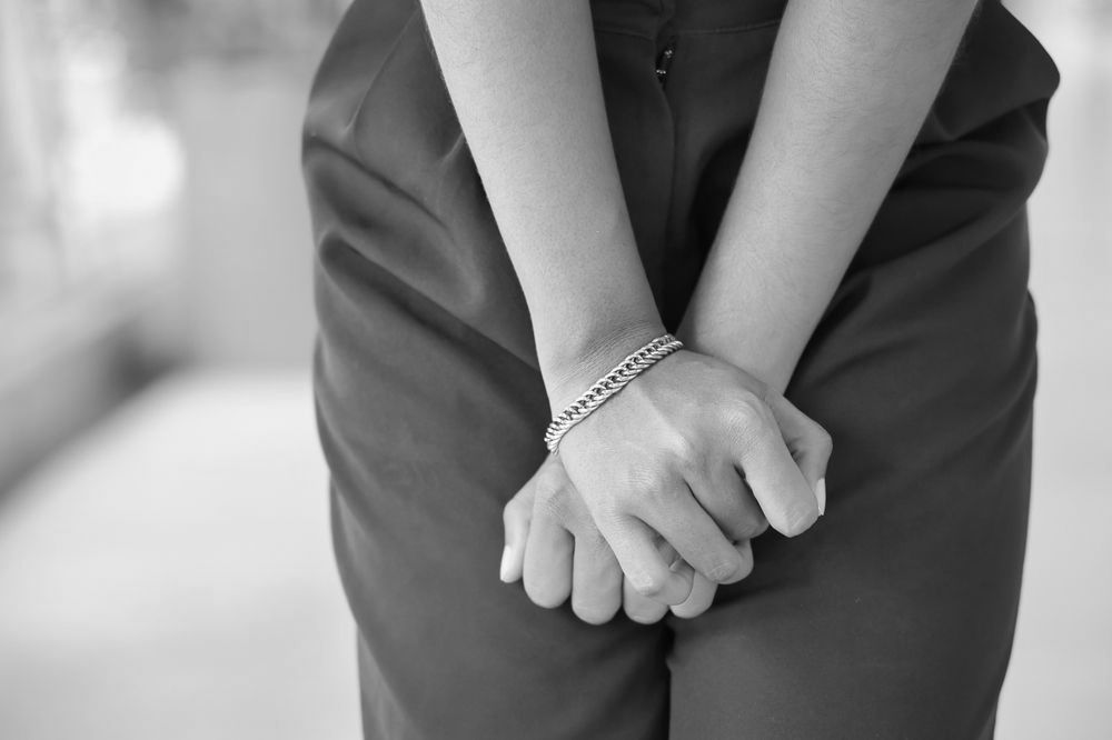 A woman with UTI discomfort wearing a bracelet.