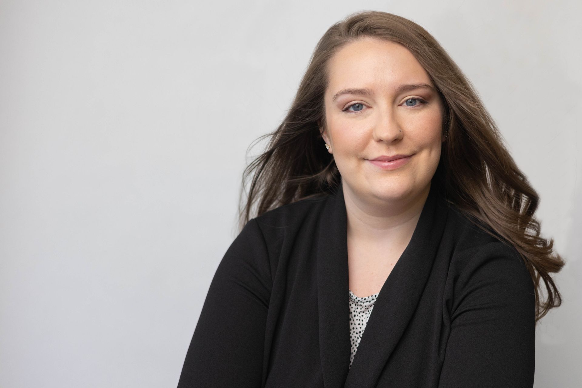 The woman is wearing a black sweater and smiling for the camera.