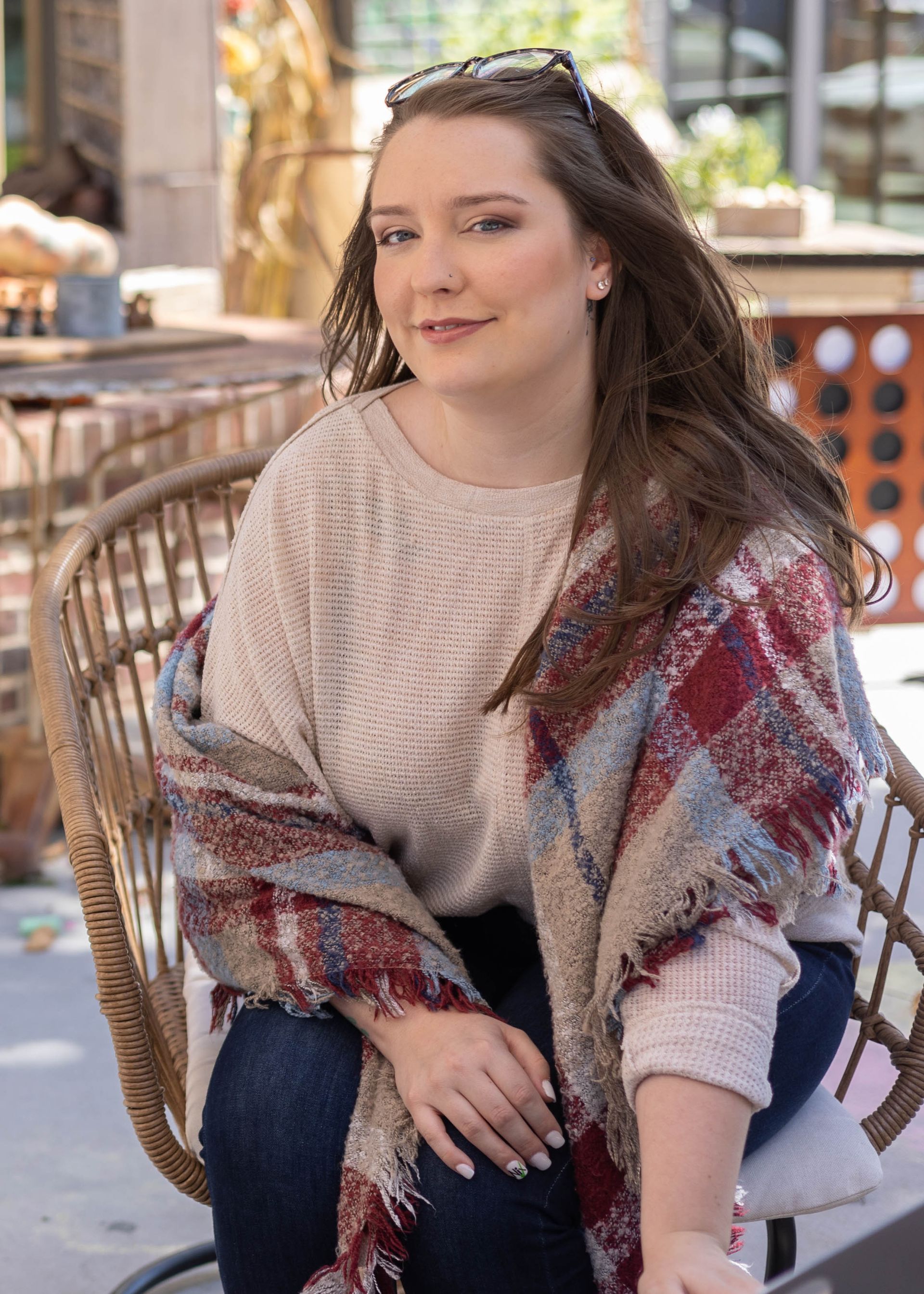 A woman is sitting in a chair wearing a scarf and a sweater.