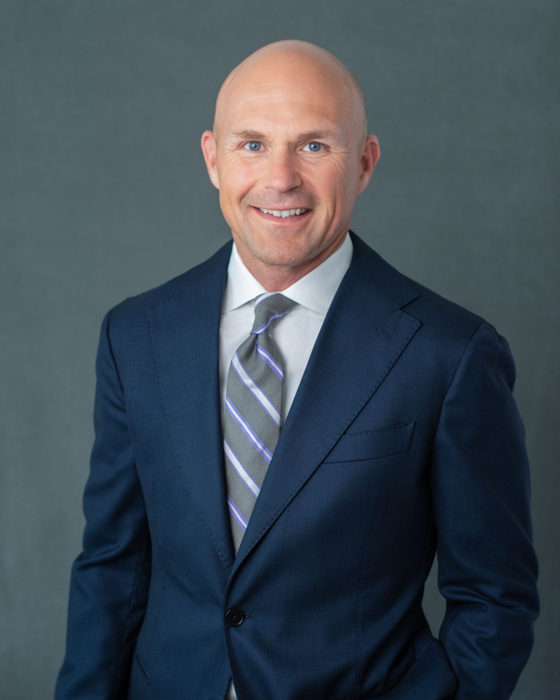 A man in a suit and tie is smiling for the camera.