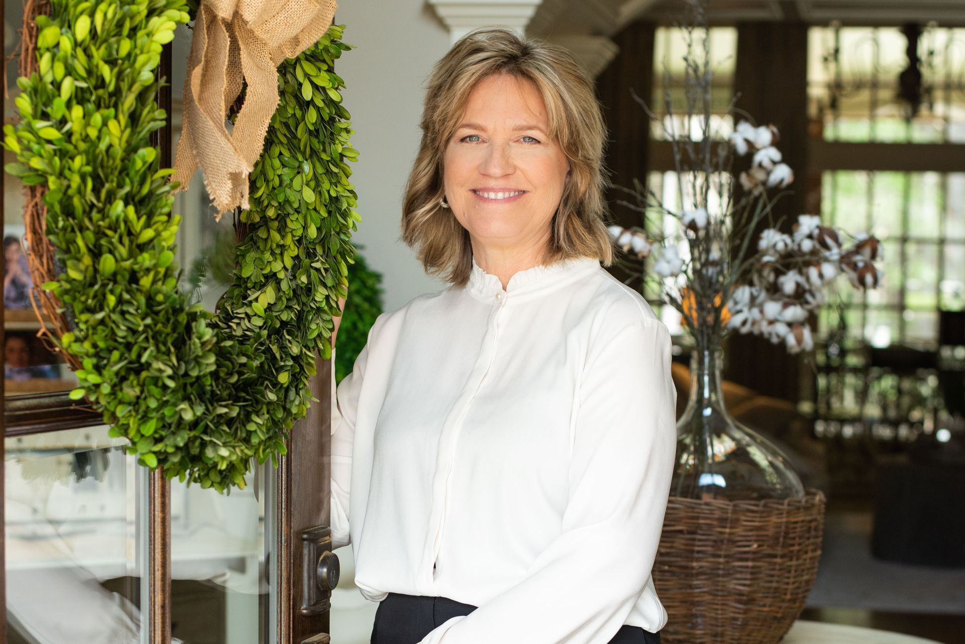 A woman in a white shirt is standing in a living room.