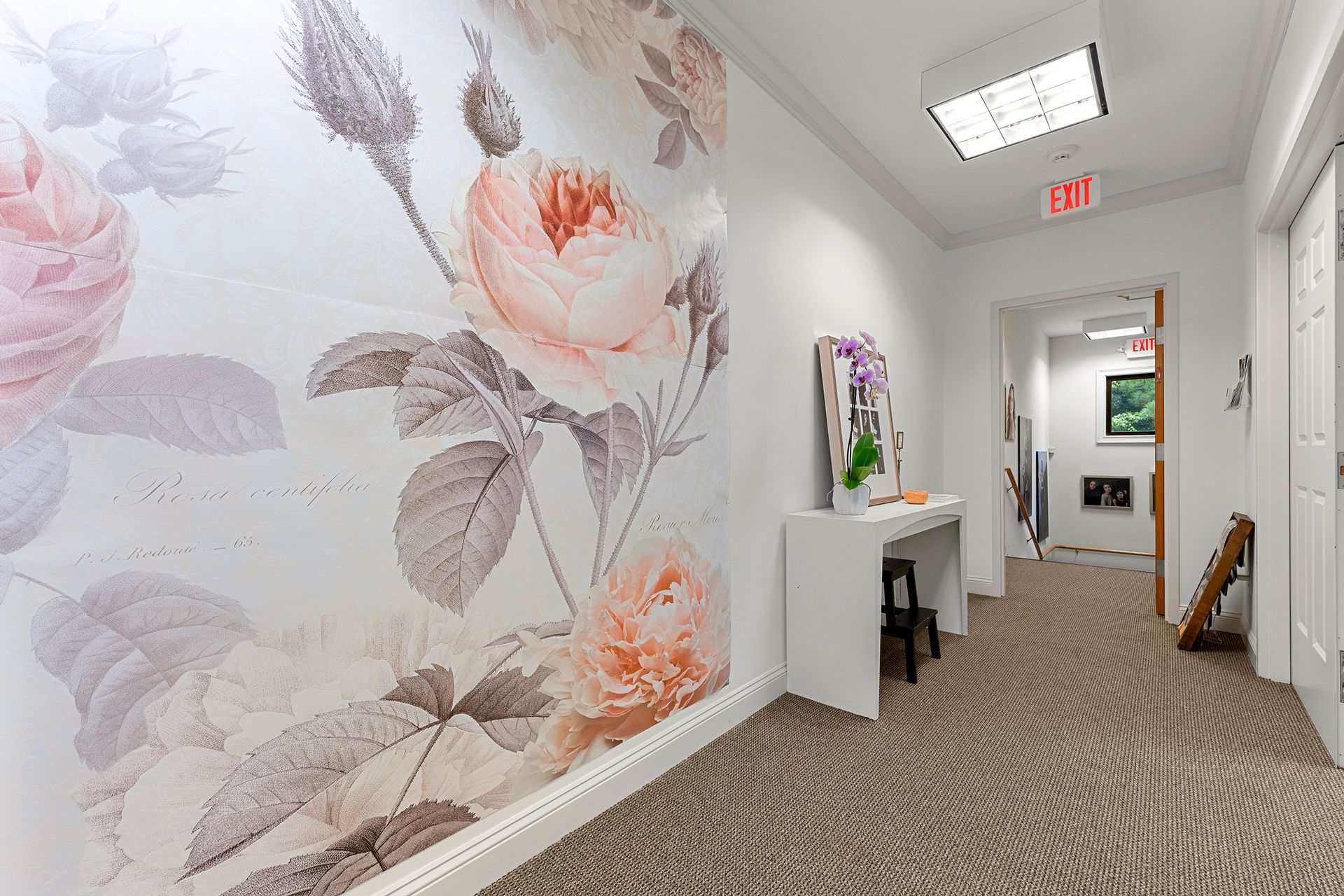 A hallway with a floral wallpaper on the wall.