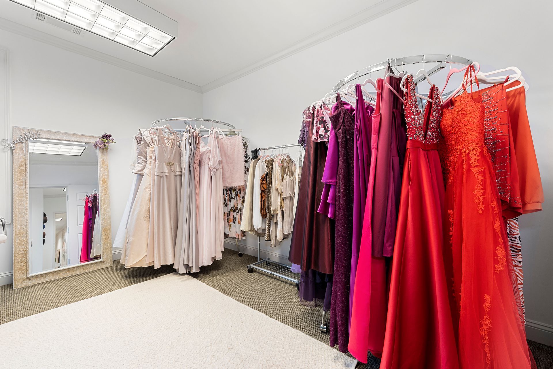 A room filled with lots of dresses hanging on racks.