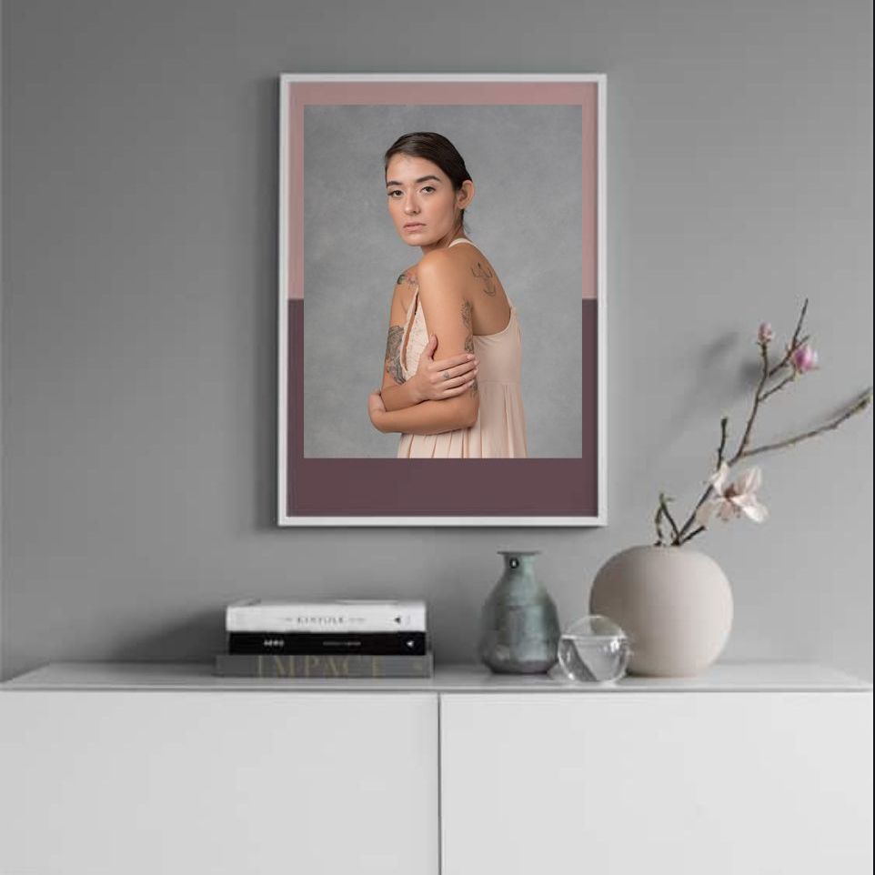 A picture of a woman in a pink dress is hanging on a wall.