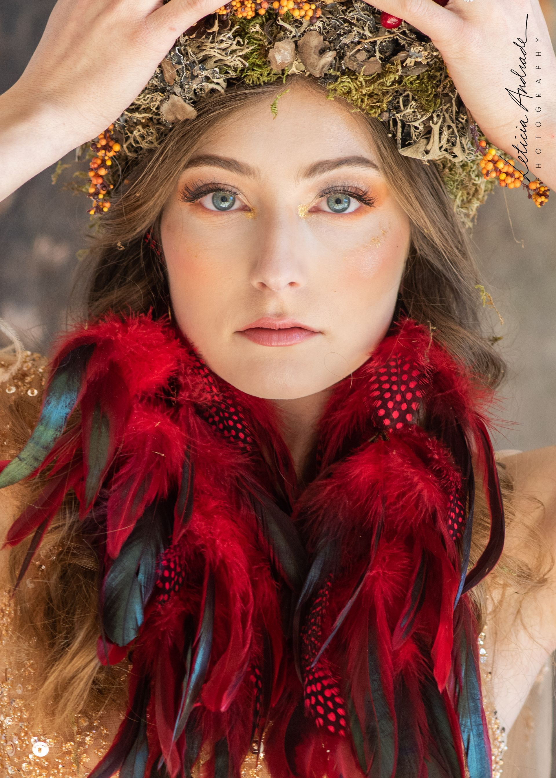 A woman wearing a crown and a scarf with feathers around her neck.