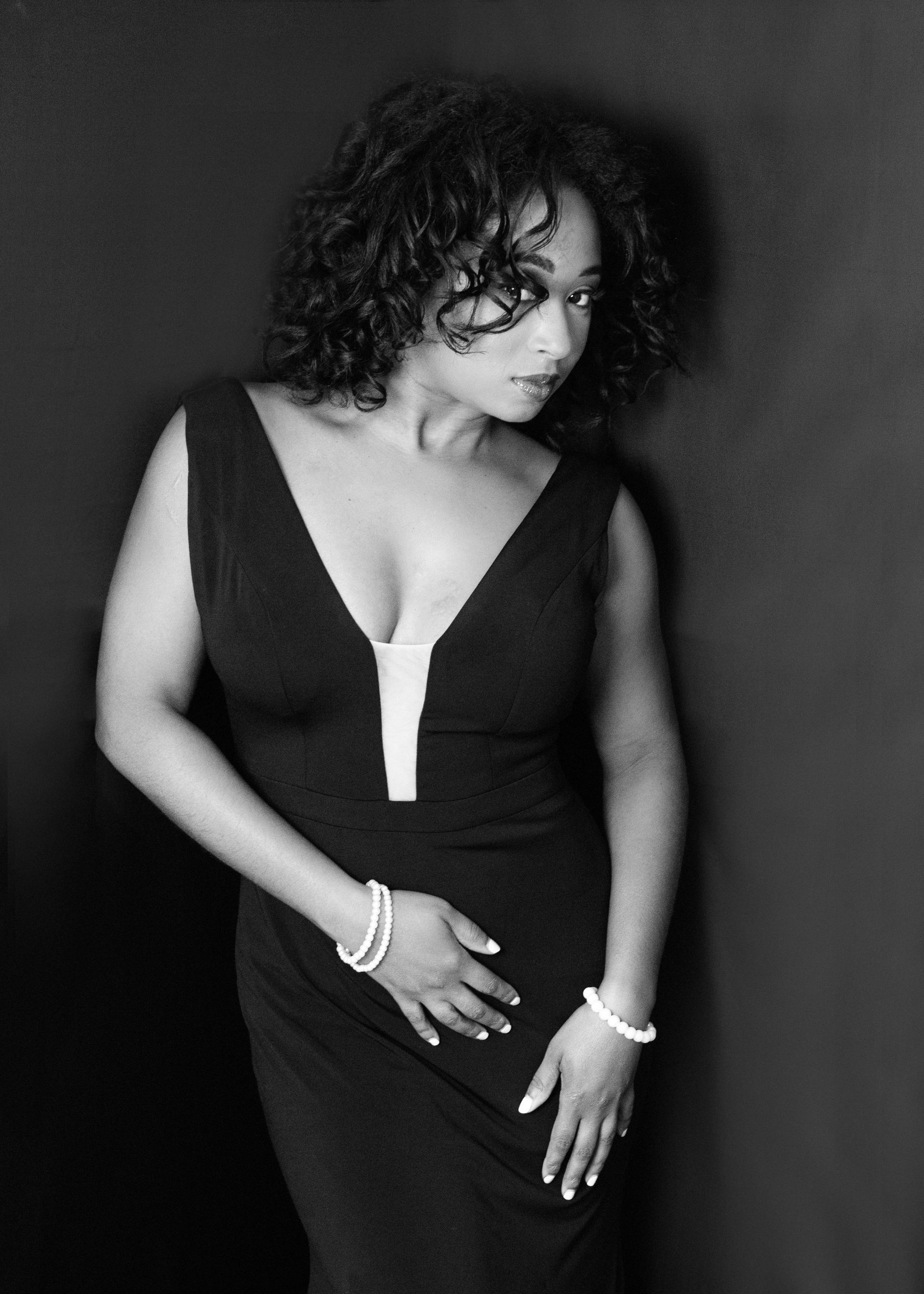 A black and white photo of a woman in a black dress