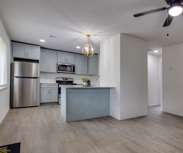 Spacious modern apartment interior at Legacy@LaHacienda in Owasso, Oklahoma featuring open floor plan, large windows, contemporary finishes, updated kitchen appliances, multifamily apartment community, residential leasing, property management, asset management, long-term apartment rentals.