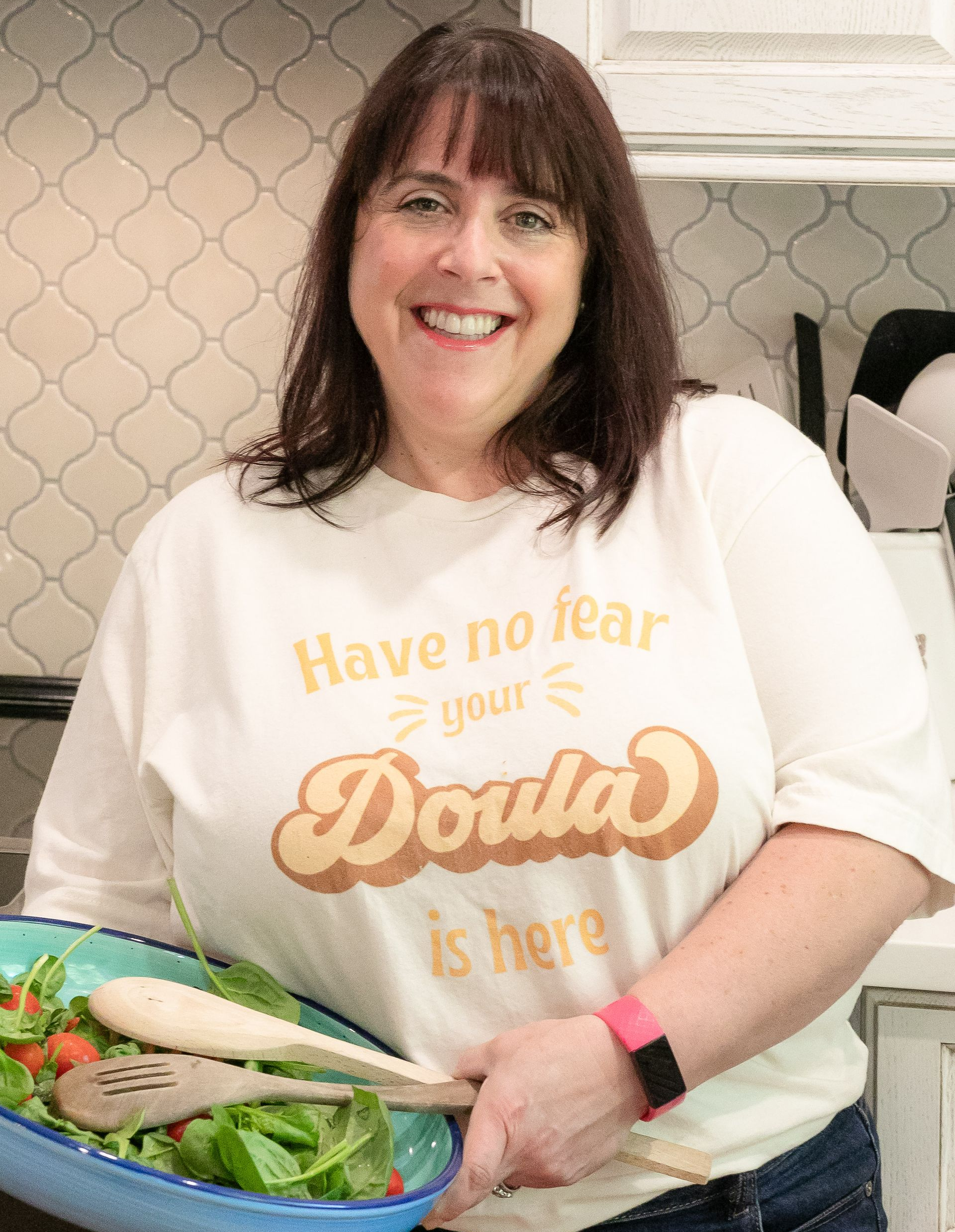 A postpartum mother is holding a baby 's feet in their hands.
