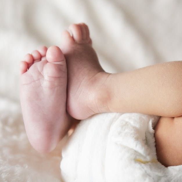 A close up of a baby 's feet on a bed.