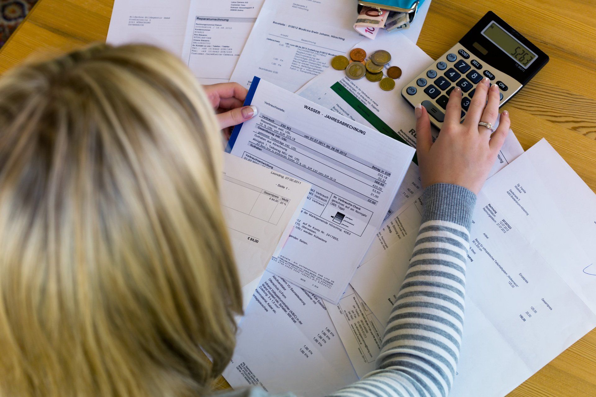 A woman is using a calculator to calculate her bills