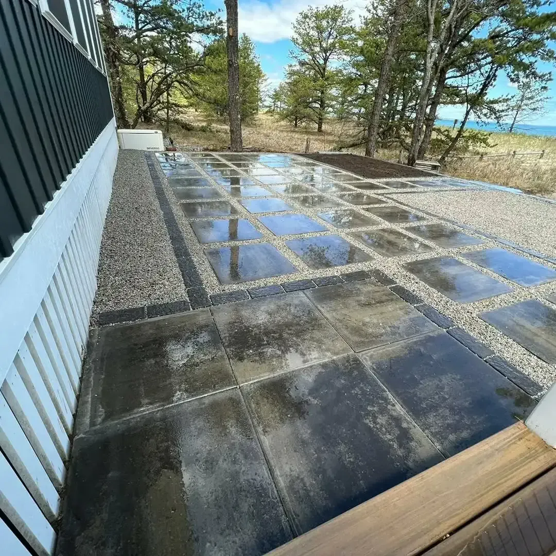 A patio with a lot of tiles and trees in the background