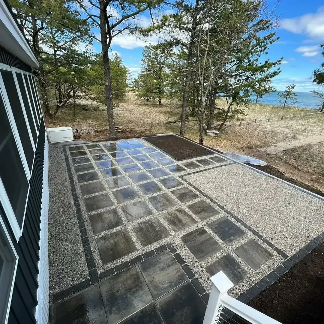 A patio with a view of the ocean and trees.
