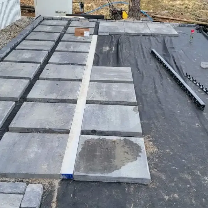 A row of concrete tiles sitting on top of a black tarp.