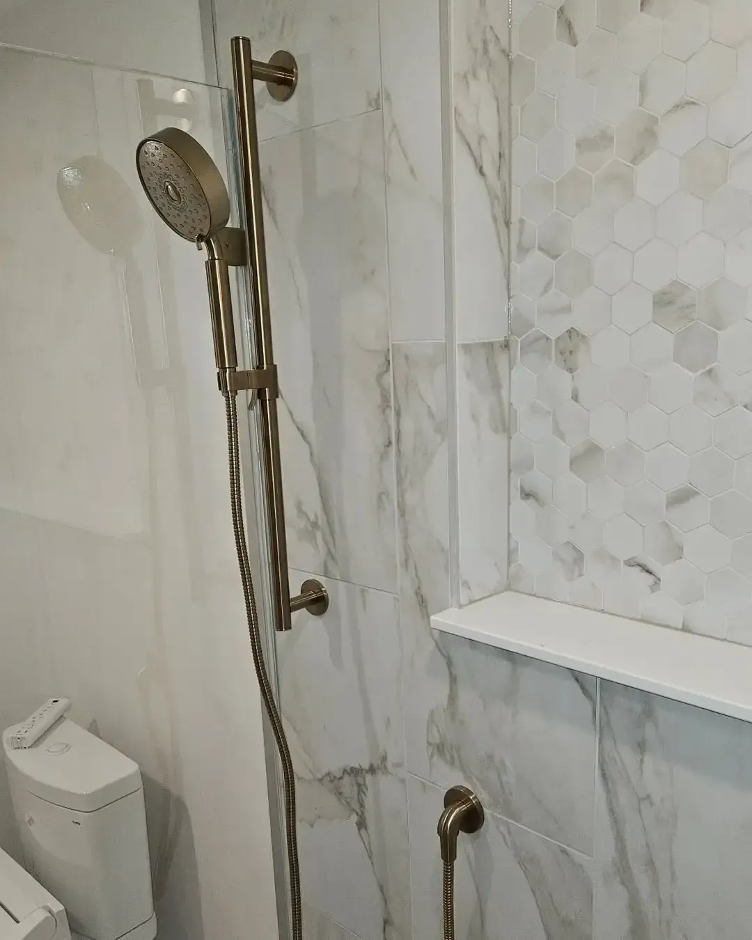A bathroom with a shower head and a toilet.