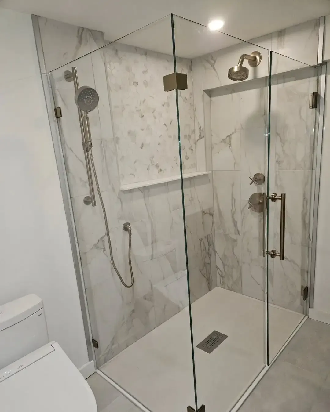 A bathroom with a walk in shower and a toilet.