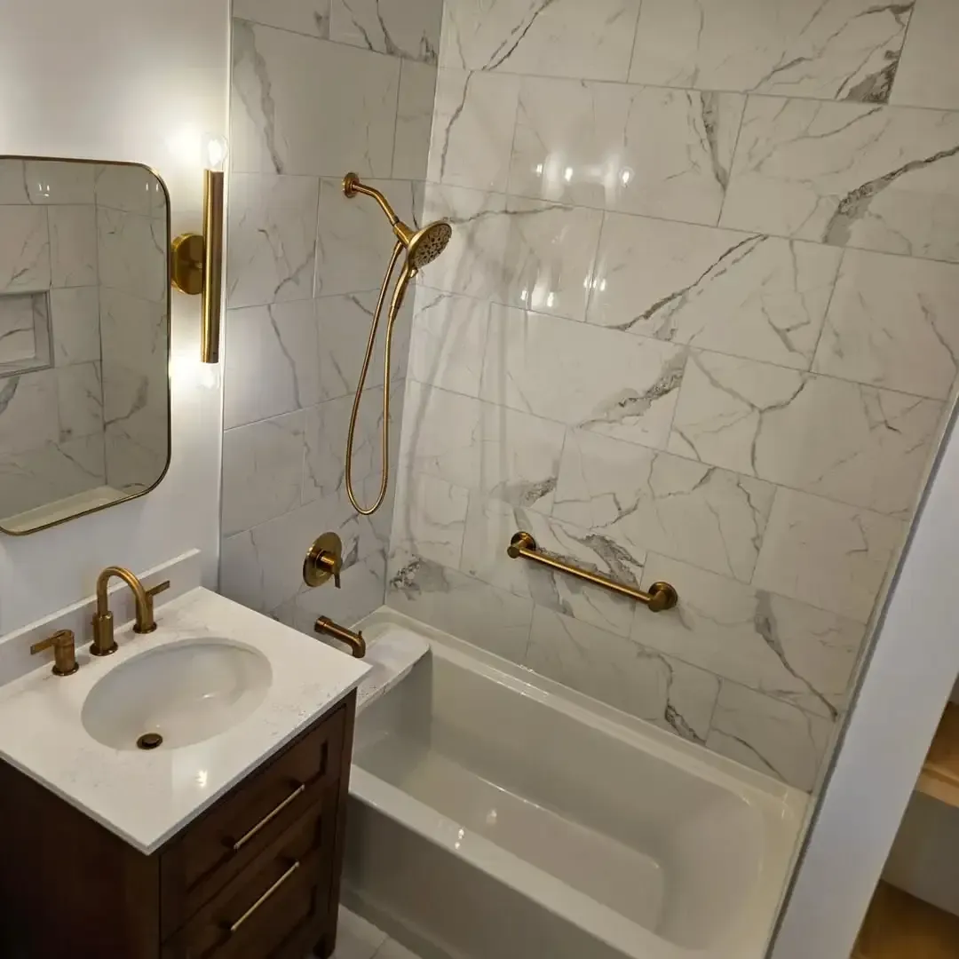 A bathroom with a sink , tub , shower and mirror.