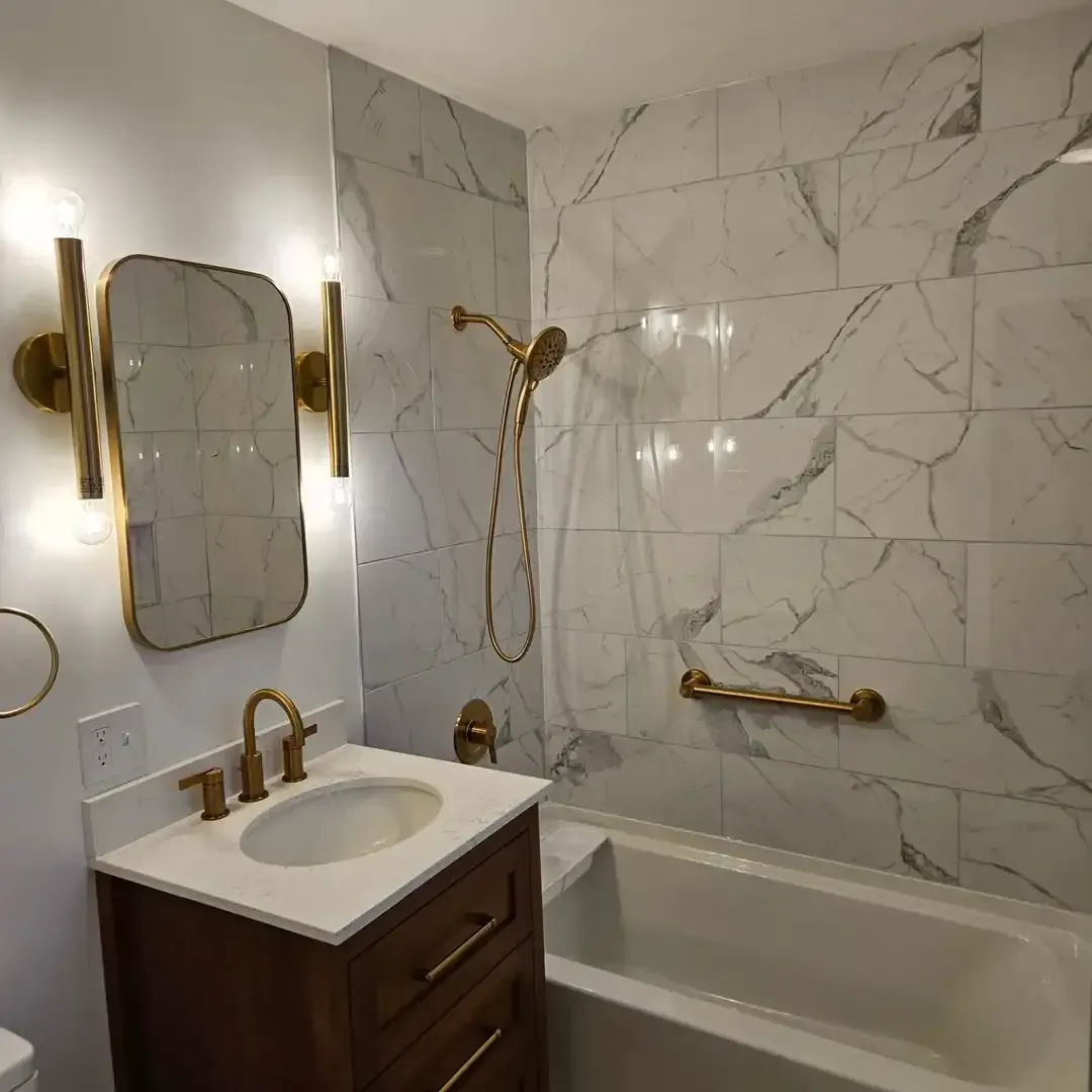 A bathroom with a sink , tub , shower and mirror.