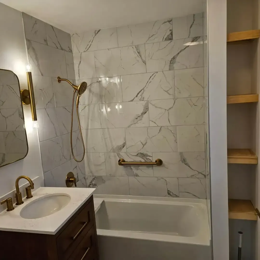 A bathroom with a sink , tub , shower and mirror.