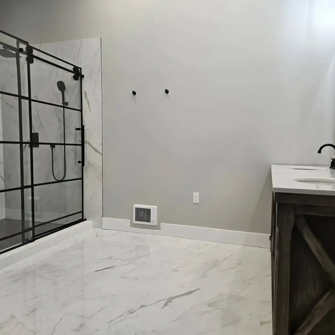 A bathroom with a sliding glass shower door and a sink