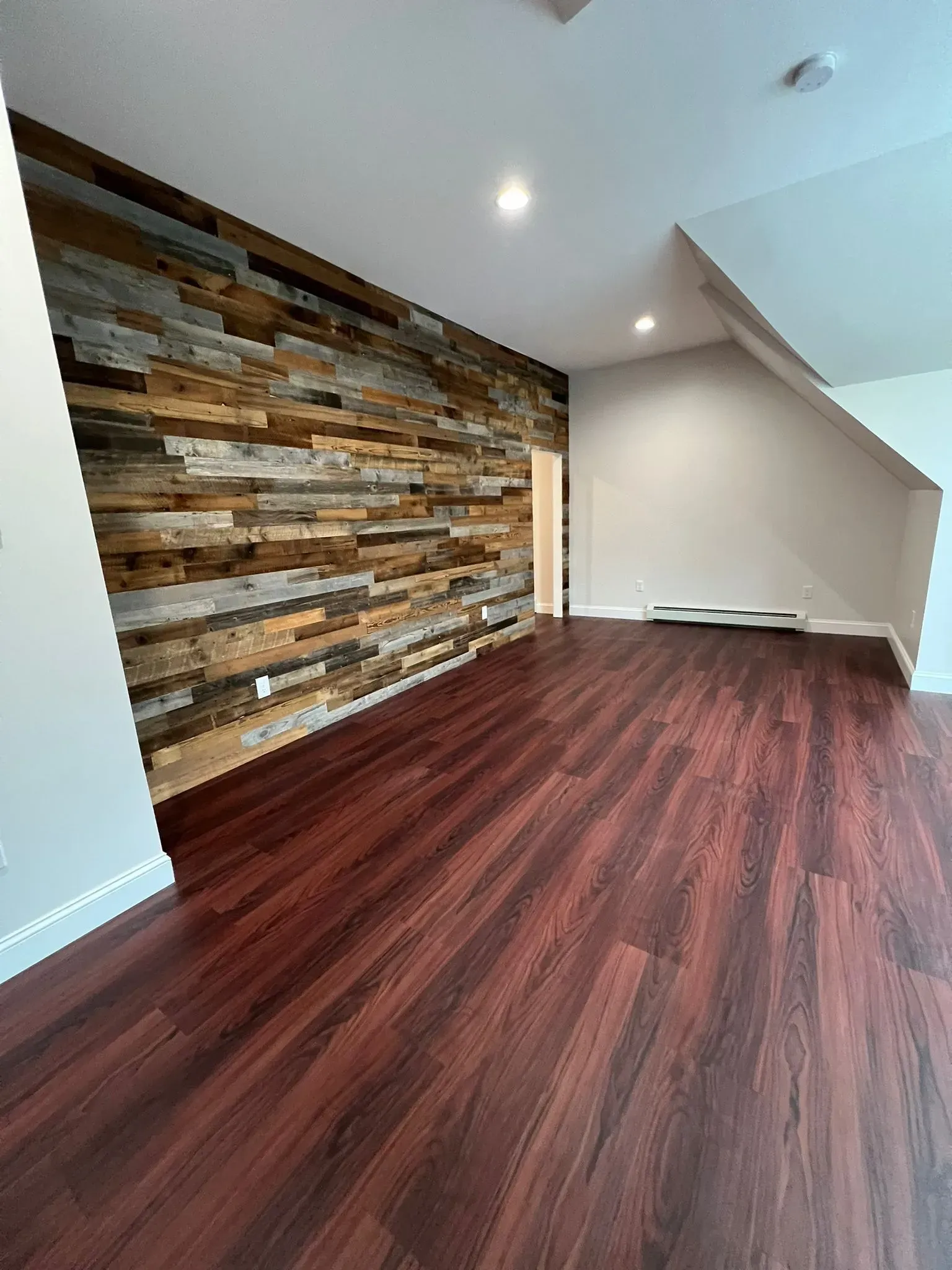 A living room with hardwood floors and a wooden wall.