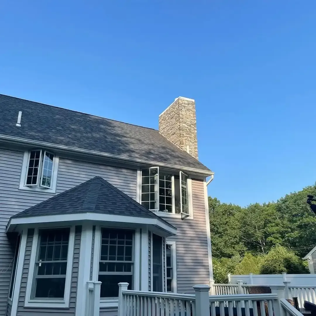 A large house with a chimney on the roof and a balcony.